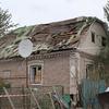 Поврежденный кирпичный дом с разрушенной крышей в Краматорске, Украина. К зданию по-прежнему прикреплена спутниковая антенна.