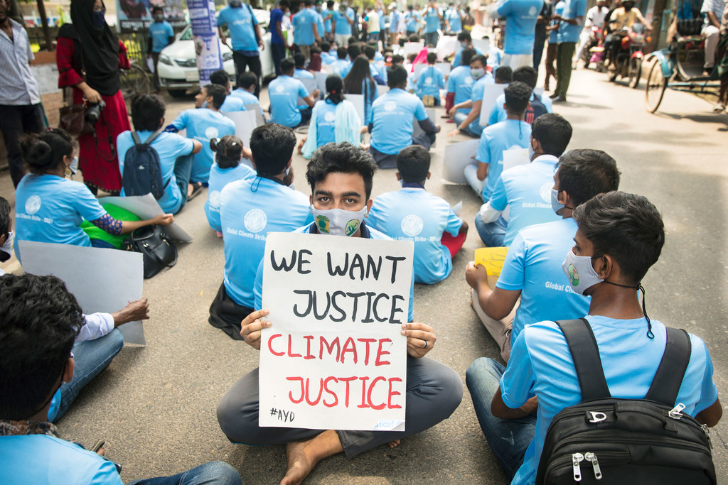 Jóvenes activistas se sientan en la calle como forma de protesta en solidaridad con la Huelga Climática Global en Bangladesh.