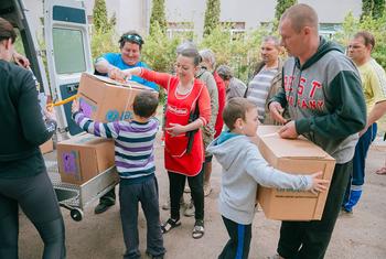 Une famille reçoit de l'aide humanitaire dans un centre de santé à Kharkiv, en Ukraine.