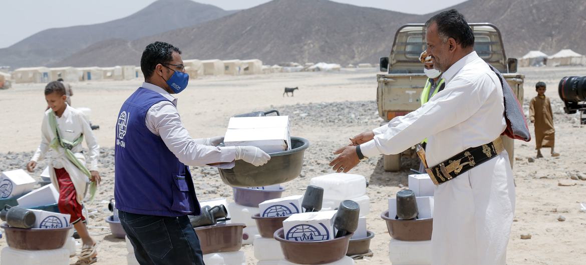 An IOM worker distributes aid kits to newly displaced communities in Ma’rib, Yemen.