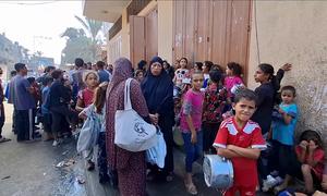 Gazans line up to fetch food assistance in the enclave where hunger levels have skyrocketed since the conflict erupted in October 2023.