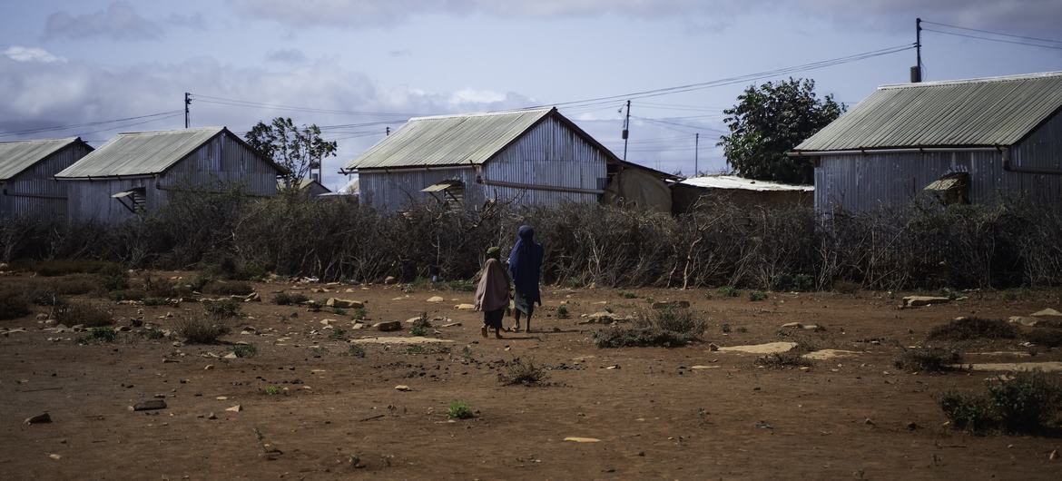 Two young girls walk through a displacement camp in southern Somalia, where families uprooted by drought are sheltering. Two young girls walk through a displacement camp in southern Somalia, where families uprooted by drought are sheltering.