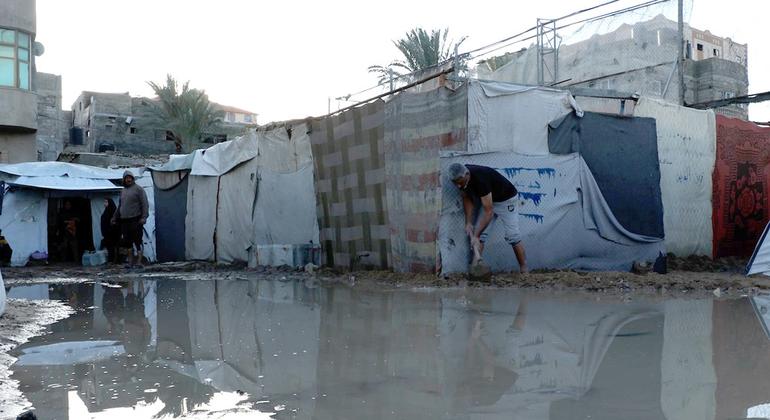 يقوم الأهالي ببناء حواجز رملية حول خيامهم بعد أن غمرتها الأمطار الغزيرة لمنع دخول المياه إليها مرة أخرى.