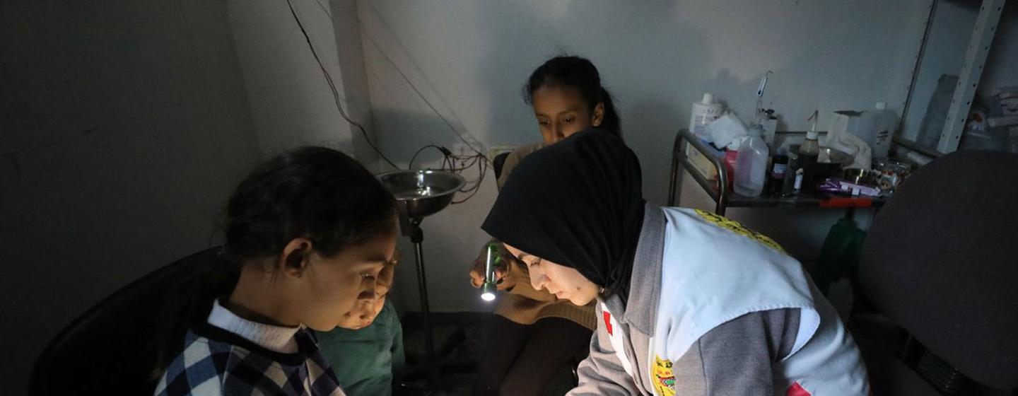 在加沙的一家医院，一名卫生工作者用绷带包扎一名儿童的脚。