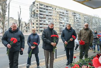 Верховный комиссар Филиппо Гранди вместе с представителями местных властей возлагает цветы к жилому дому, разрушенному в результате ракетного удара в Днепре.