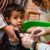 Un niño recibe una vacuna de un trabajador sanitario en Ghwairan, Hasakeh, Siria.