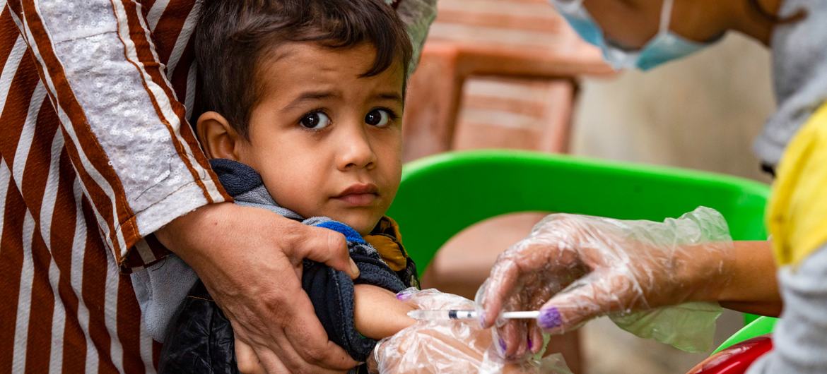 Uma criança recebeu uma vacina de um trabalhador do Departamento de Saúde no bairro de Ghwairan, na cidade de Hasakeh, nordeste da Síria, em 26 de outubro de 2022.
