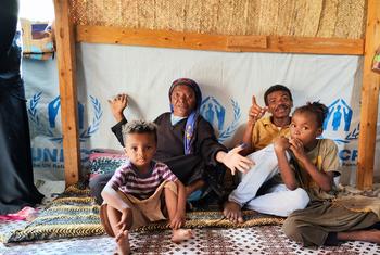 也门亚丁的一个流离失所者营地，一个家庭坐在庇护所里。