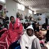 Migrantes sentados en el interior de un edificio de un centro de detención en Libia (archivo).