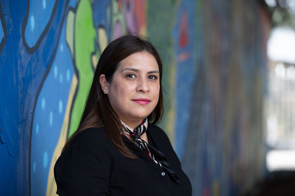 La defensora de los derechos humanos Alejandra Ortiz posa frente a un colorido mural en Monterrey, México.