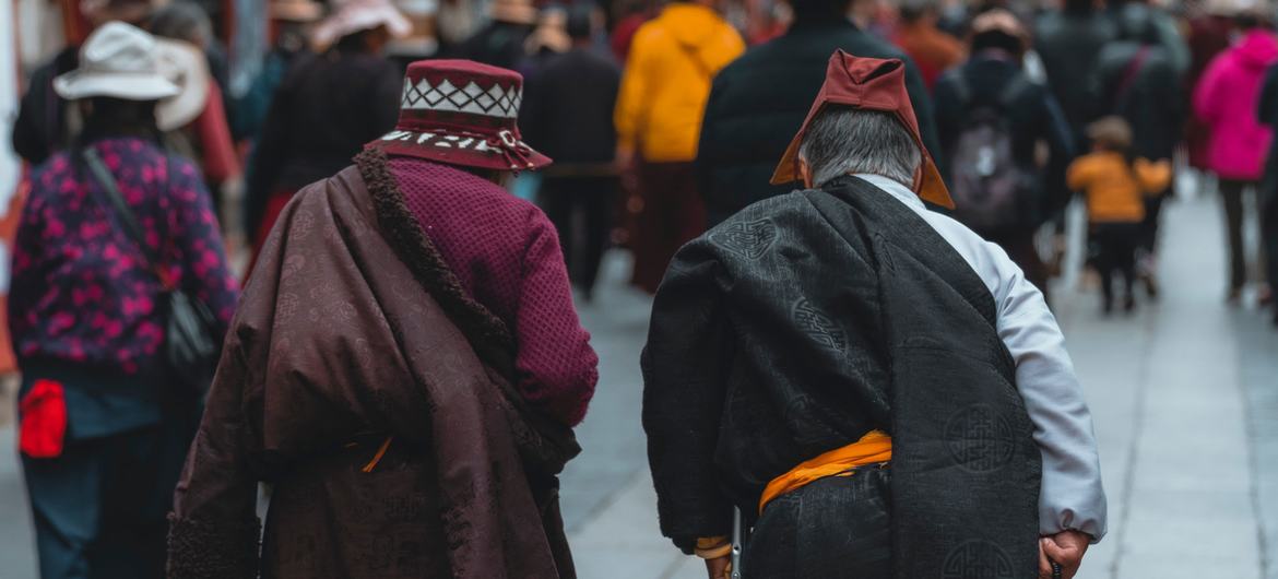 Two elderly Tibetan people walk to a religious event in Lhasa.