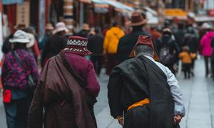 Two elderly Tibetan people walk to a religious event in Lhasa.
