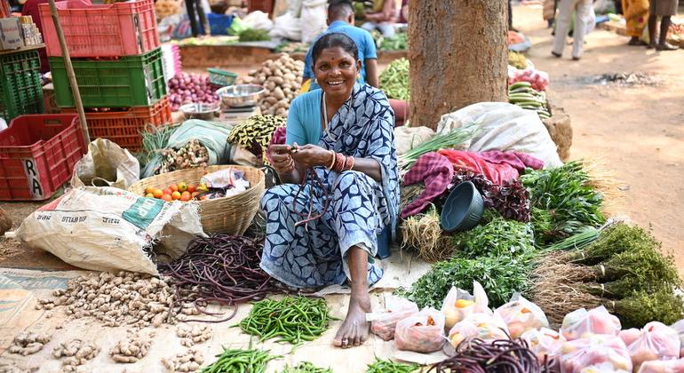 Женщина из племенной общины продает продукцию на местном рынке.