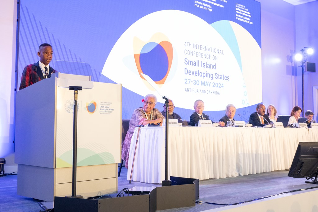 A speaker at a podium addresses a panel at the 4th International Conference on Small Island Developing States in Antigua and Barbuda.