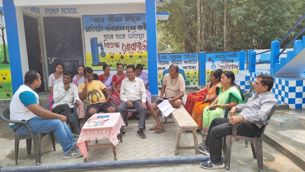 UNOPS के एक जिला सलाहकार ने पंप हाउस में समुदाय के सदस्यों के एक समूह को जल परीक्षण की प्रक्रिया और जल गुणवत्ता के महत्व के बारे में समझाया।