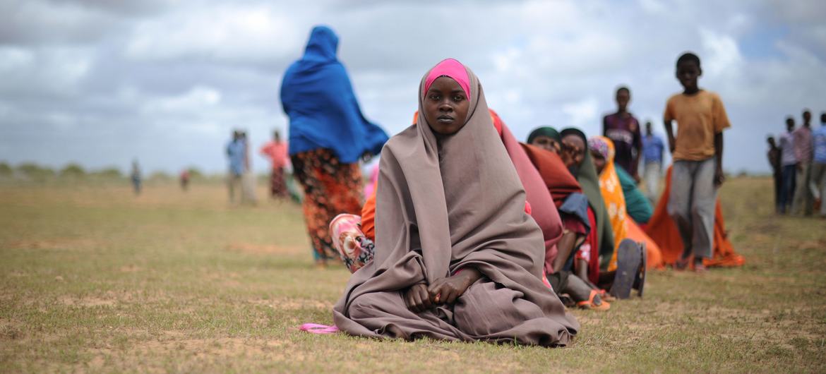 نساء ينتظرن وصول المساعدات الغذائية في مركز توزيع في أفغوي، الصومال.