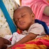 Mtoto mchanga wa Kiafrika aliyelala amepumzika mikononi mwa mama katika Kituo cha Afya cha Mama na Mtoto cha El Mina nchini Mauritania wakati wa Wiki ya Chanjo ya Afrika.