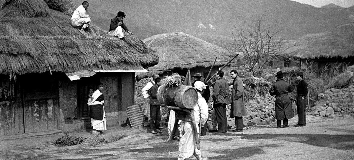 На этой фотографии 1951 года члены Комиссии ООН по объединению и восстановлению Кореи посещают корейскую деревню.