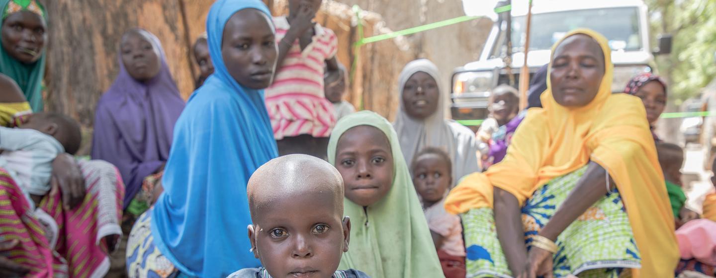 Des bénéficiaires attendent à un point de distribution d'aide alimentaire et nutritionnelle du PAM dans un village de la région de Zinder, au Niger.