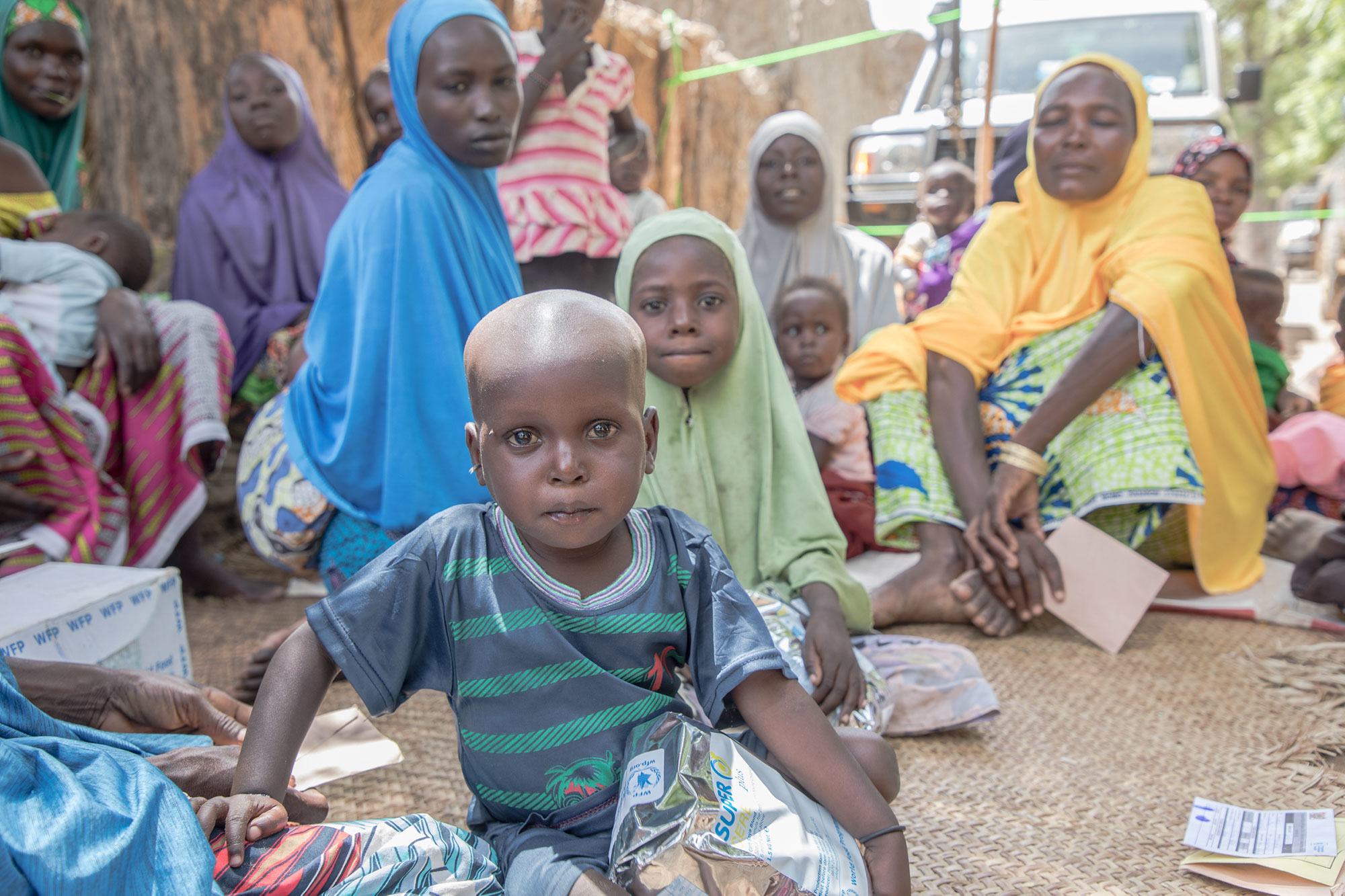 在尼日尔津德尔地区的一个村庄，受益者在世界粮食计划署粮食和营养援助分发点等候。