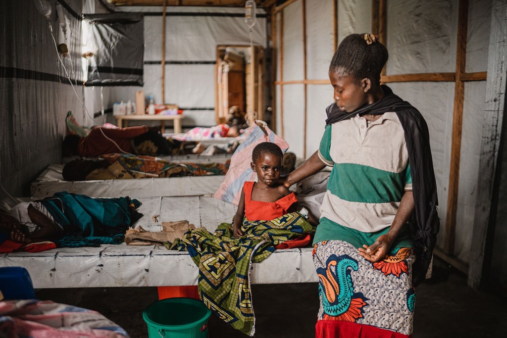 Une femme est assise à côté de sa fille, qui a contracté le choléra et est en convalescence dans un centre de santé près de Goma, suite à l'épidémie de choléra.