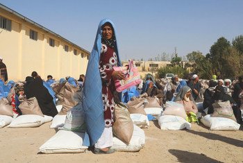 People receive food rations at a WFP distribution site on the outskirts of Herat in Afghanistan.