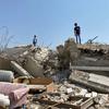 Children stand on a home demolished in Beit Sira, a Palestinian village in the central West Bank.