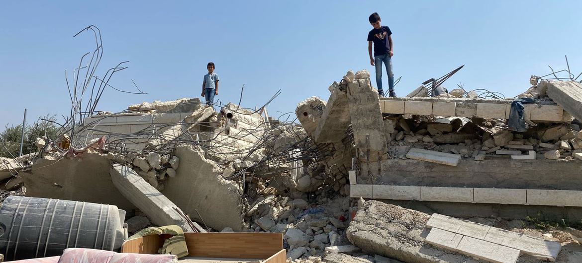 Children stand on a home demolished in Beit Sira, a Palestinian village in the central West Bank.