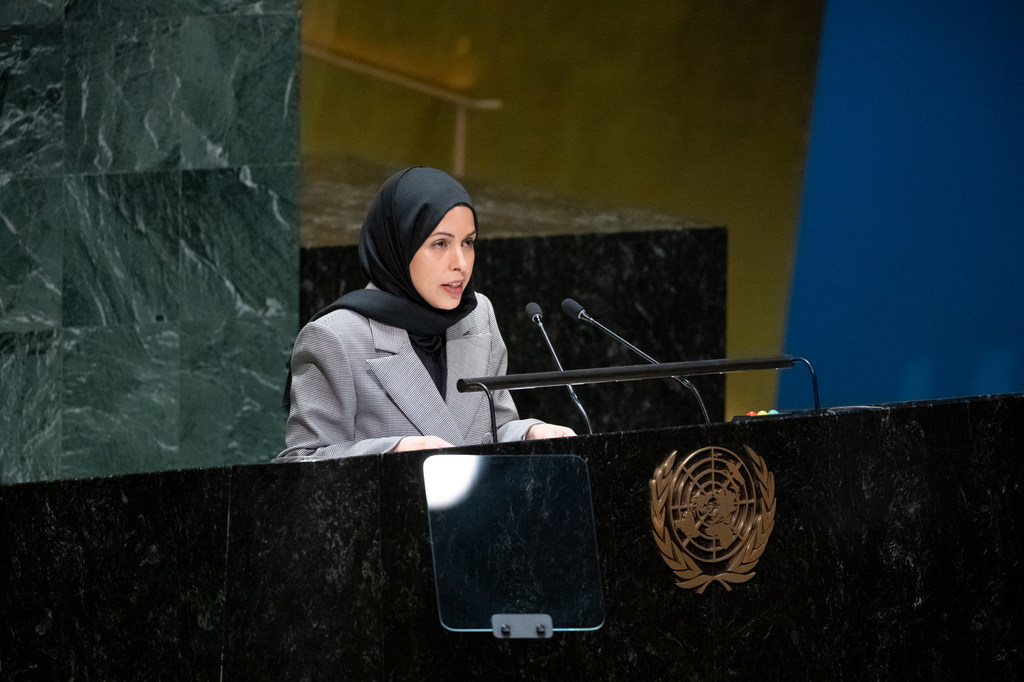 دبلوماسية قطرية تتحدث من على منصة تحمل شعار United Nations .