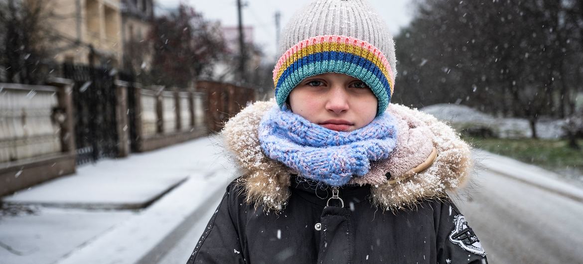 An eight-year-old girl stands outside her home in a village in Uhryniv in Ukraine.