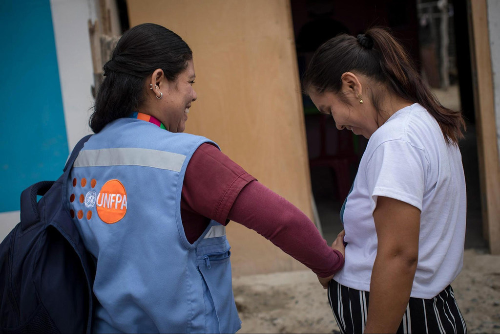 Акушерка ЮНФПА и беременная женщина в Перу.
