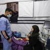 一名医护人员在加沙照顾受伤的儿童。
