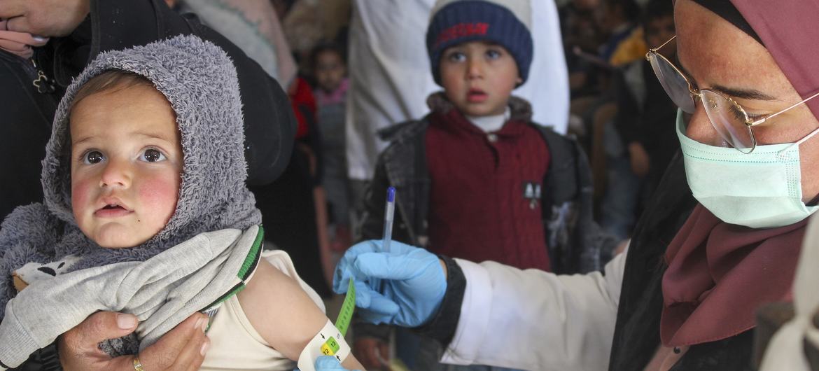 A one-year-old child is screened for malnutrition by a UNICEF-supported health team in Syria.