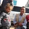 سامر عبد الجابر، مدير تنسيق الطوارئ في WFP، يقف لالتقاط صورة مع فتاتين صغيرتين خلال زيارة ميدانية.