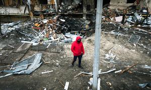在乌克兰基辅，一名男子在爆炸留下的弹坑前行走。