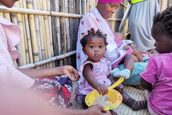Uma mãe alimentando seu bebê com uma refeição que salva vidas no Distrito de Mecufi, Província de Cabo Delgado, Moçambique.