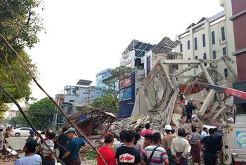 People gather in front of collapsed buildings in the Mandalay region of central Myanmar, following the 7.7 magnitude earthquake.
