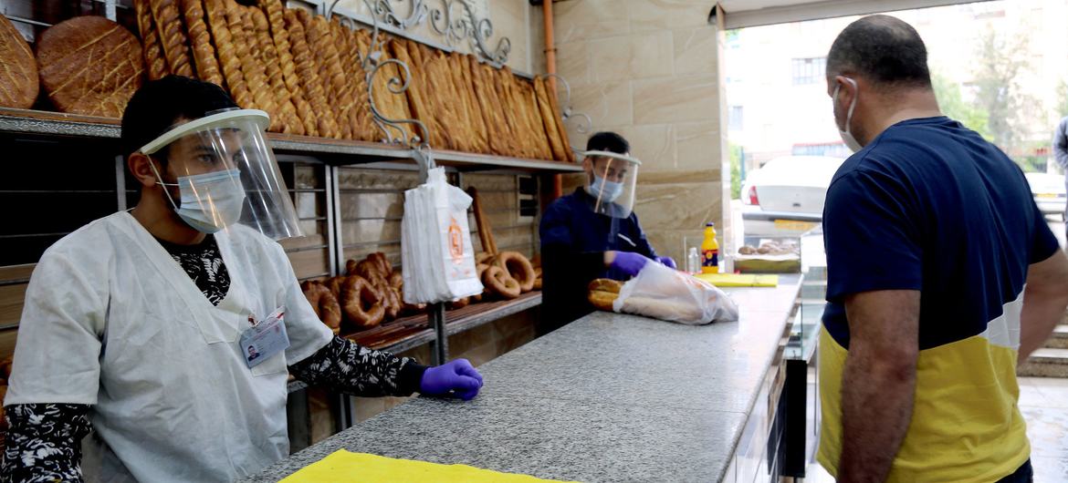 Dükkan çalışanları, COVID-19 salgını sırasında Cezayir'in Konstantin kentindeki bir fırında ekmek satıyorlar.