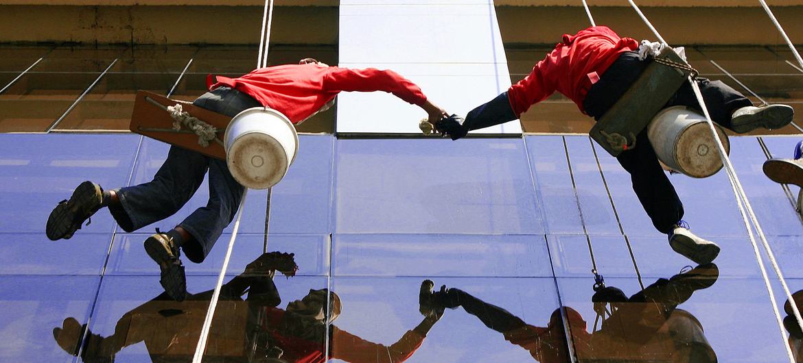 فیلپائن میں کارکن ایک بڑی بلڈنگ کی کھڑکیاں صاف کرتے ہوئے۔