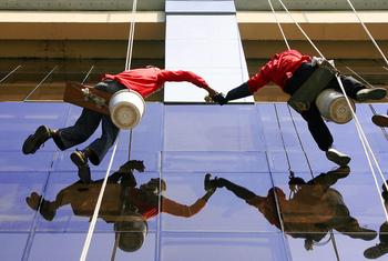 Window cleaners work in Muntinlupa City, Philippines.