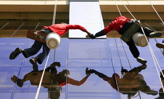 فیلپائن میں کارکن ایک بڑی بلڈنگ کی کھڑکیاں صاف کرتے ہوئے۔