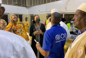 An IOM staff member assists evacuees from Sudan at N’Djamena's international airport in Chad.