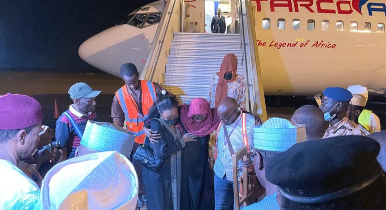 مساعدة المسافرات ممن تم إجلاؤهن من الخرطوم إلى إنجمينا على النزول من الطائرة.