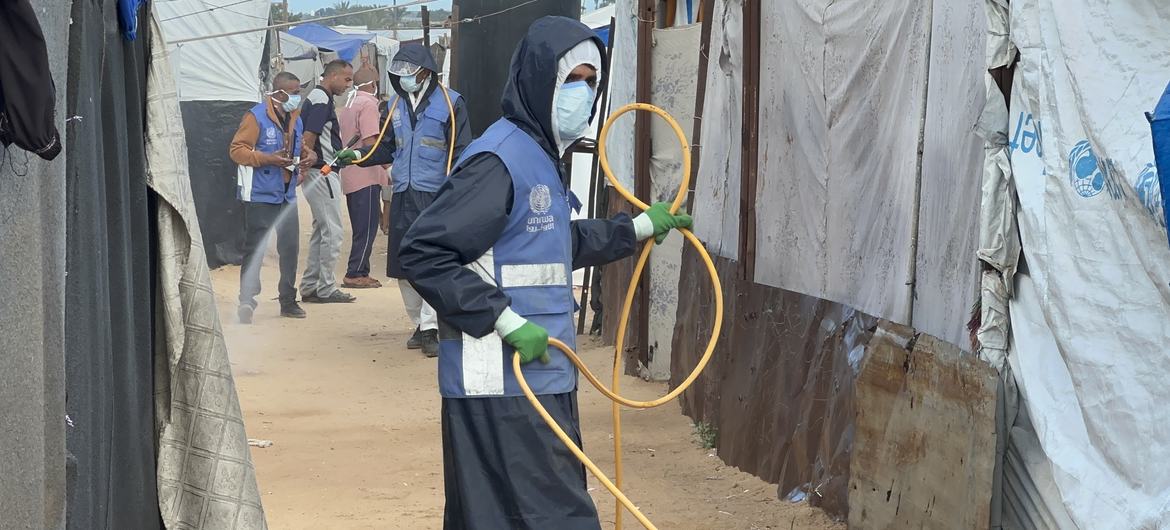 Сотрудники БАПОР распыляют инсектициды в убежищах для перемещенных лиц.