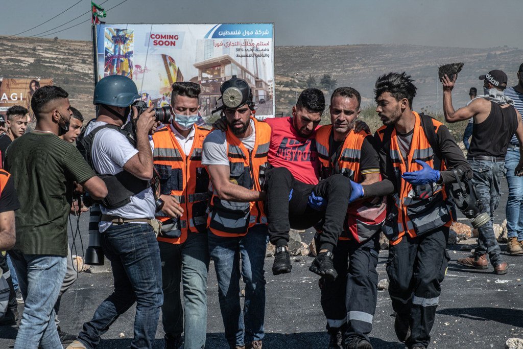 (أرشيف) عاملو إغاثة يساعدون رجلا أصيب في رام الله بالضفة الغربية في عام 2021.