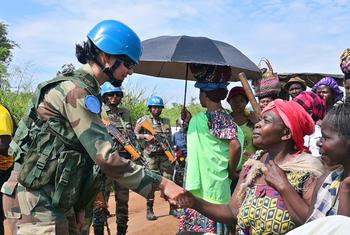 Dans l'est de la République démocratique du Congo, la commandante Radhika Sen, de la MONUSCO, salue des femmes lors d'une patrouille, instaurant ainsi la confiance.