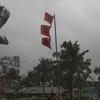 Три флага, предупреждающих о высокой опасности приближающегося шторма в деревне в Бангладеш.