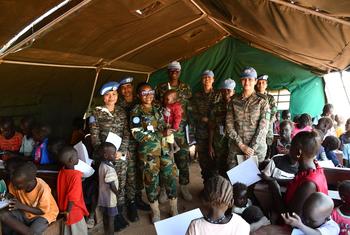 La Commandante d’escadrille Sharon Syme, originaire du Ghana (tenant un jeune garçon dans ses bras), a été nommée Défenseure militaire de l’égalité des sexes de l’ONU pour l’année 2024.