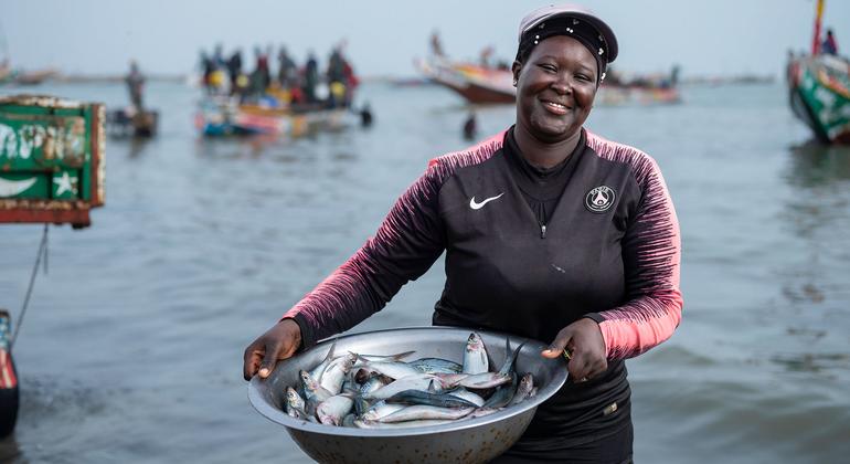Uma pescadora a caminho de vender o peixe que pescou