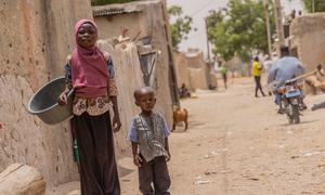 A young girl and her cousin walk through the streets of a village in southern Niger.